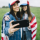 female-friends-colored-caps-taking-selfie